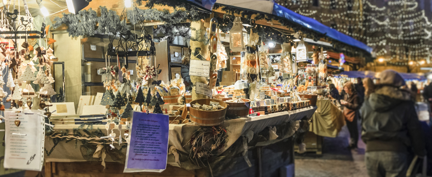 Festive market stall with decorations, wooden products and lighting creates a cozy holiday atmosphere.