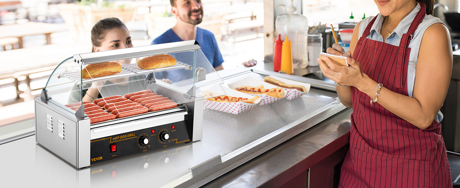 VEVOR hot dog roller in a food stand with hot dogs cooking, buns on the rack, and a server taking orders.